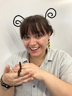 Kyleigh holds a small snake while wearing an inset antenna head piece